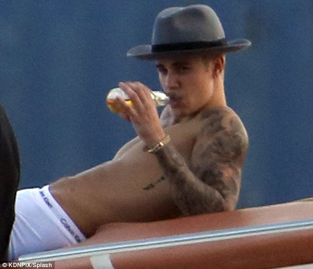 Shirtless Justin Bieber, 20, appears to sip beer as he parties with scantily …