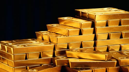 Gold lower as stocks, dollar strengthen; holds near $1300